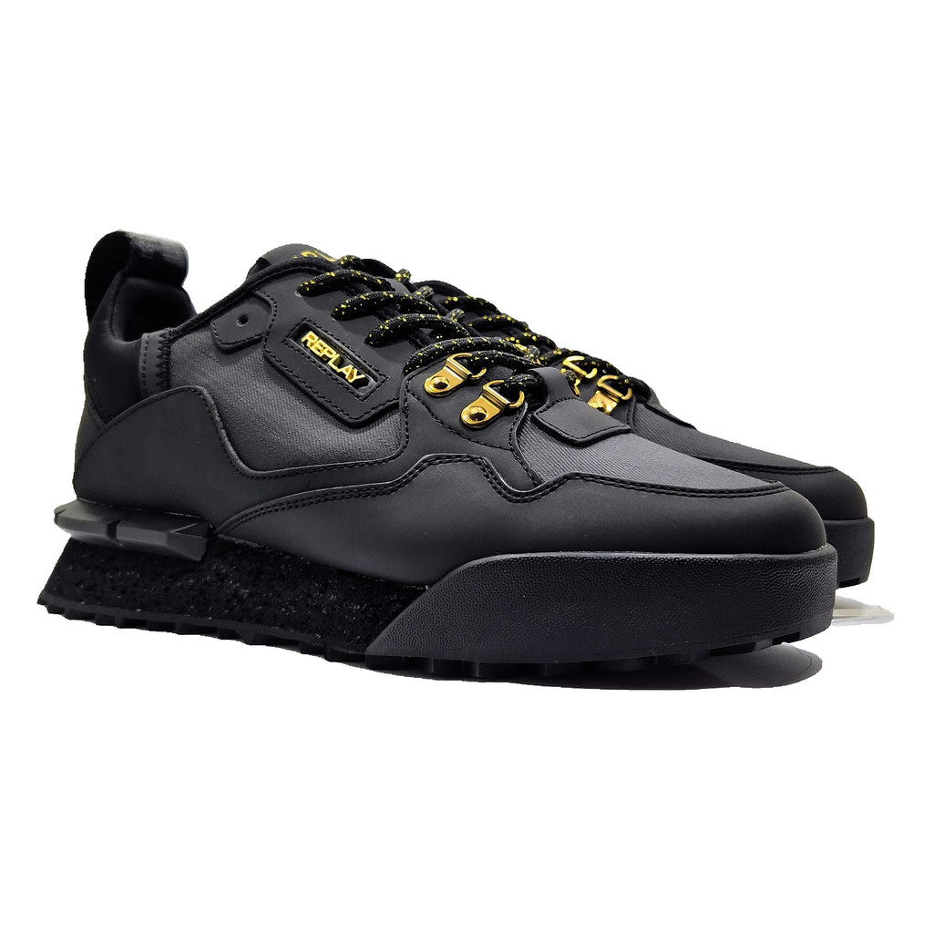 Black sneakers with yellow accents on a white background
